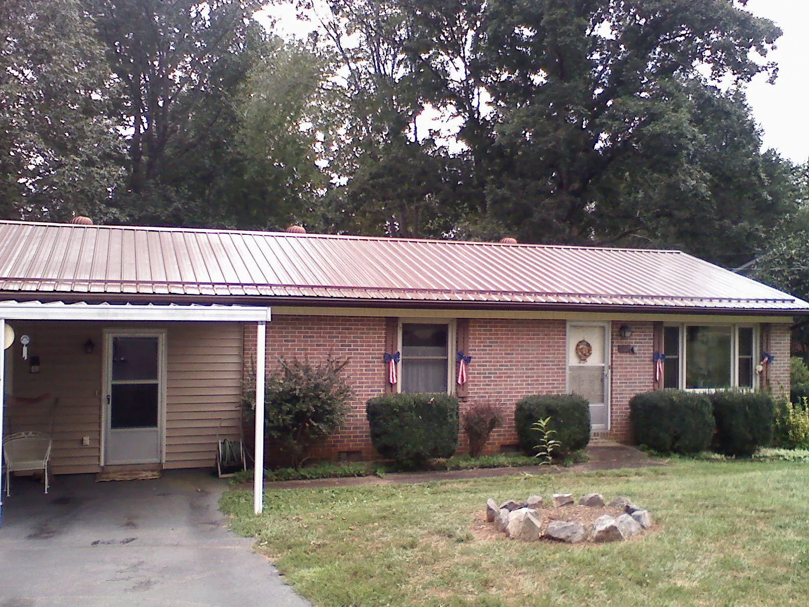 Bronze metal roof and carport on a brick ranch home — Roof Repair work by our crew in Venus